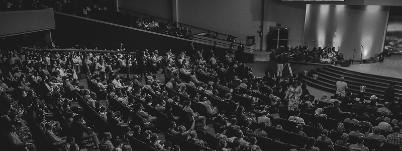 Black and white photo of a packed auditorium during a live event